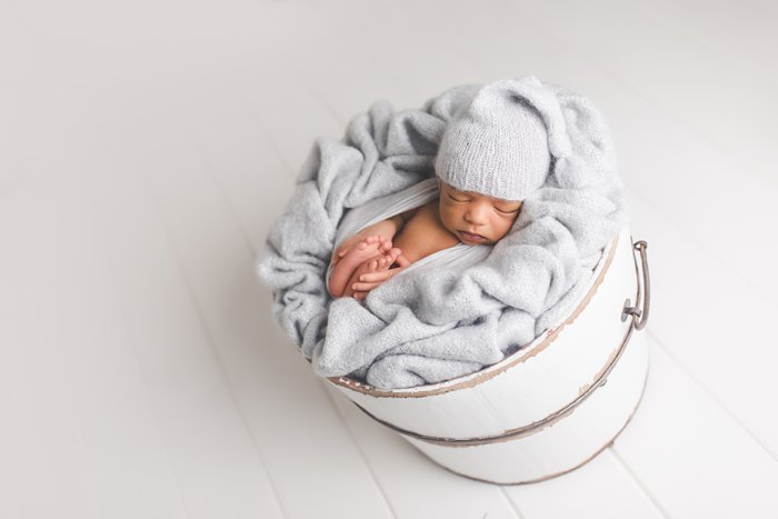 newborn baby in white bucket