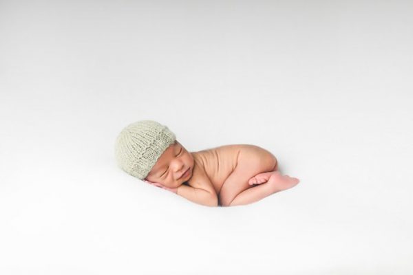 newborn baby wearing knit gray skull cap